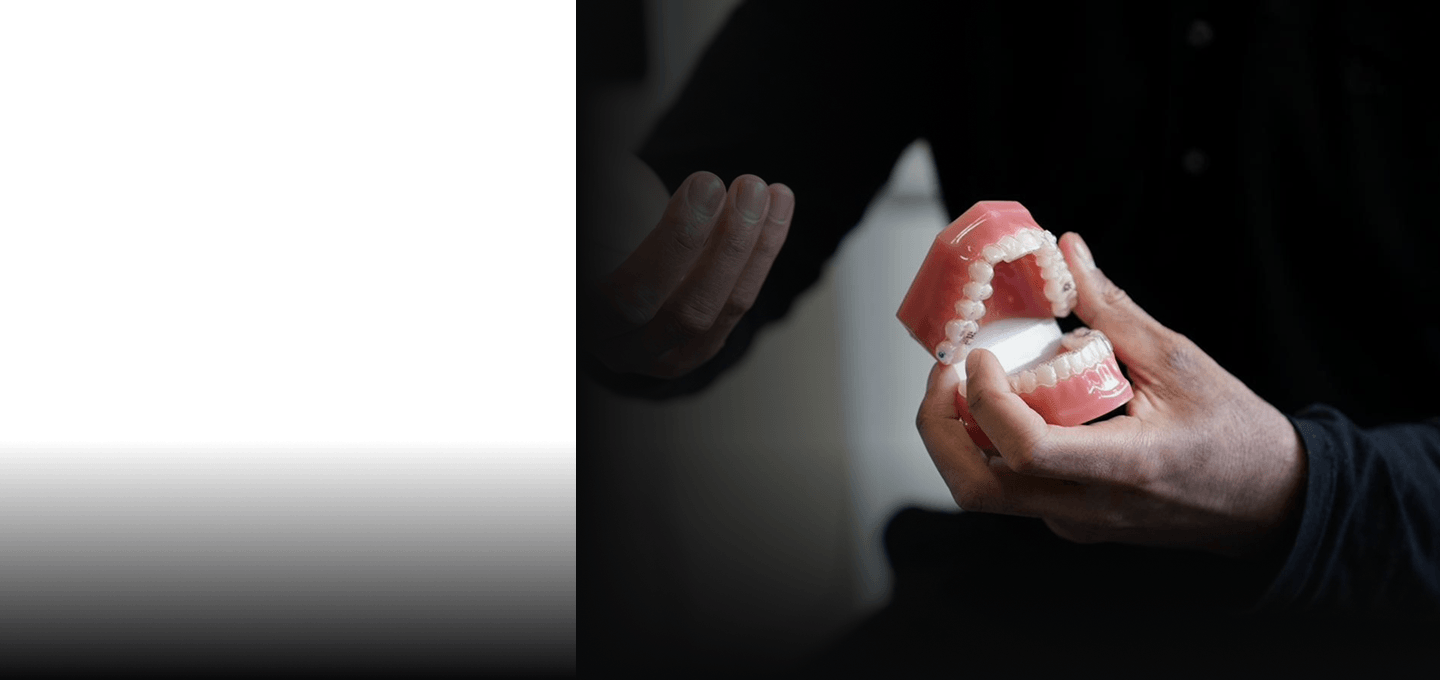 Dr Naeem holding a model of teeth to explain treatment