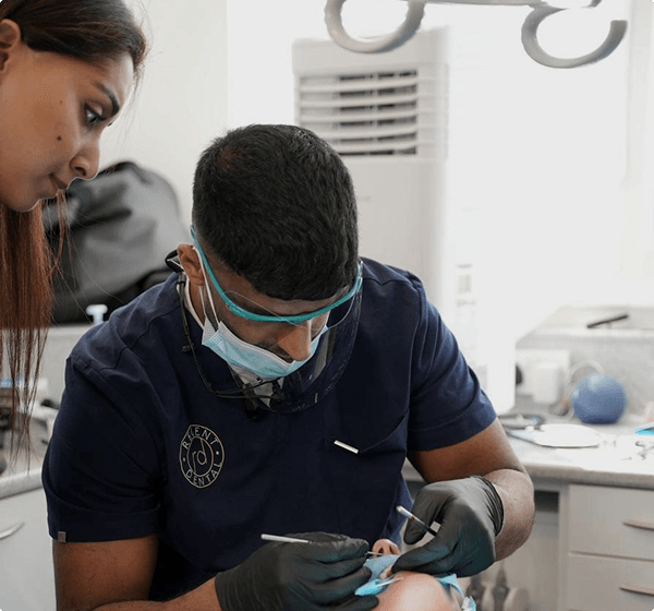 Dr Naeem Ashfaq treating a patient with his dental nurse at Regent Dental