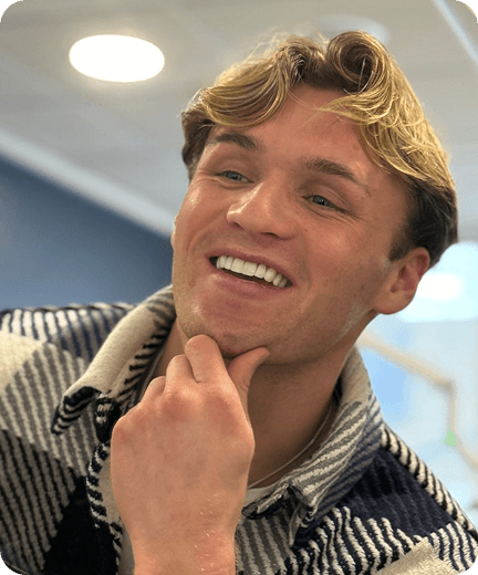 A patient smiling with his hand on his chin