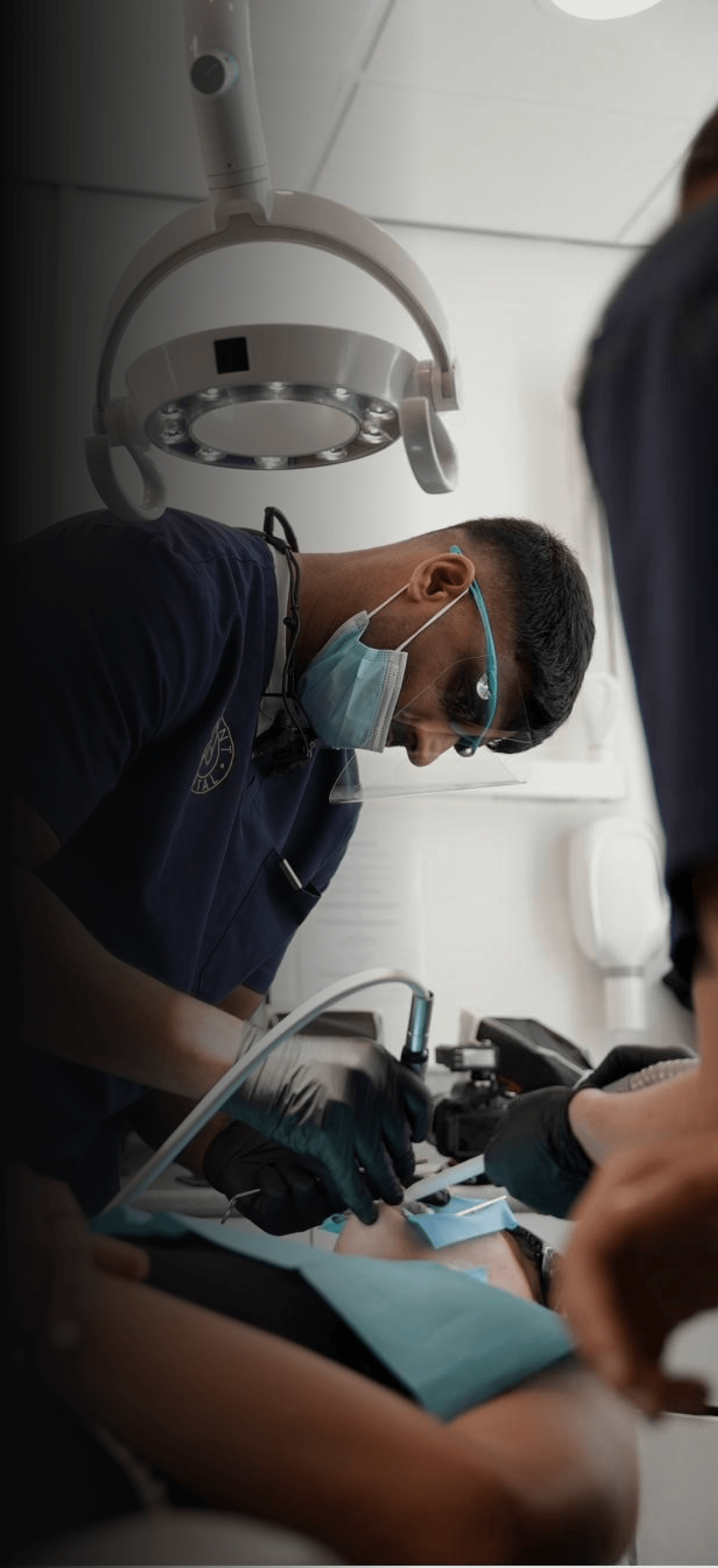 Dr Naeem Ashfaq treating a patient under the dental lamp